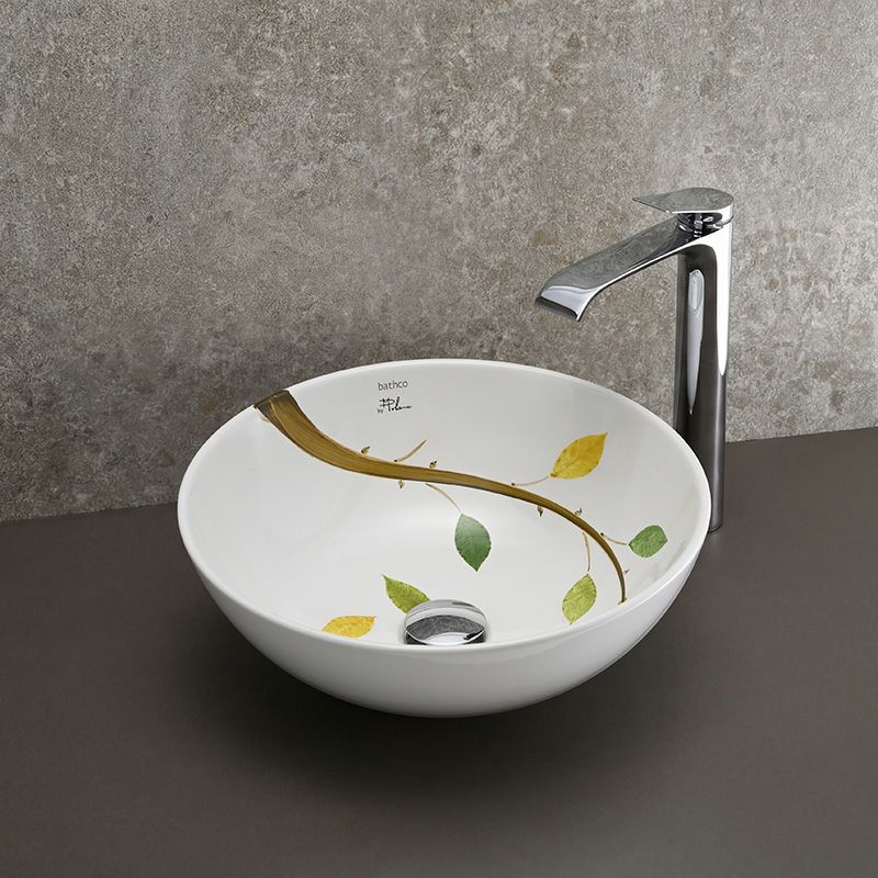 一筆書きのように描かれた枝葉が印象的な、BATHCO（スペイン）のアート陶器洗面ボウル。Φ400mm×H150mmのゆったりとしたサイズ感で、秋の情景を思わせる繊細な色彩が洗面空間に穏やかで詩的な雰囲気をもたらします。